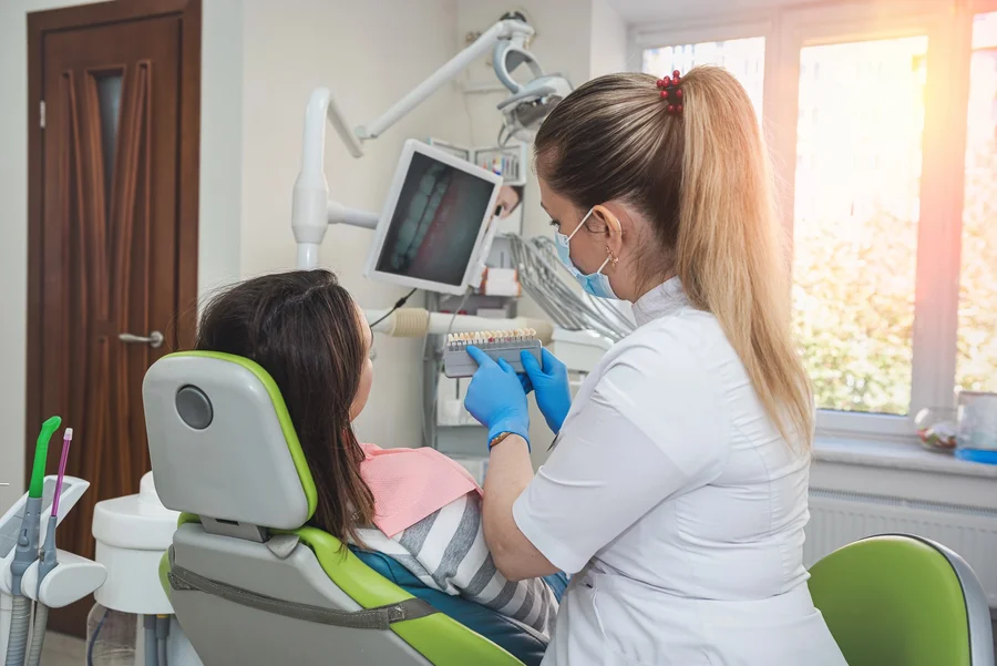 Dentist near me showing a dental shade guide to a patient