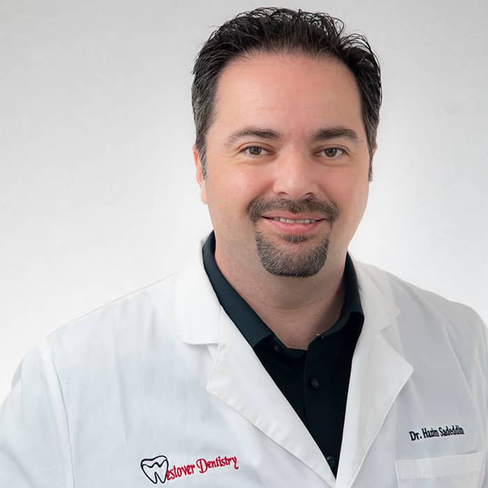Smiling man in dental coat with "Westover Dentistry" logo, white background.